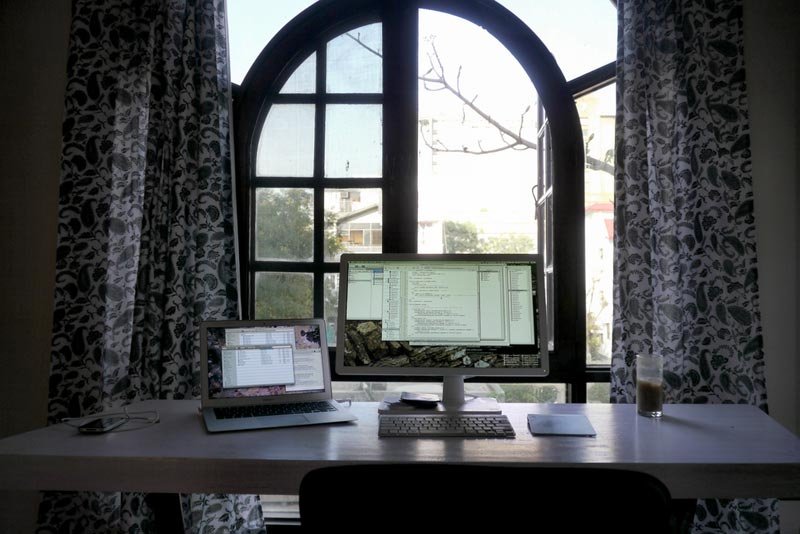 Desk with computer in front of window