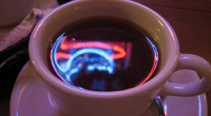 Neon lights reflected in teacup