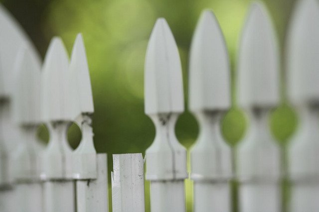 white picket fence missing top of a post