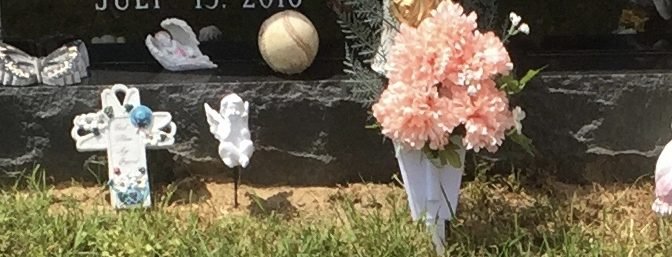 flowers and baseball on a grave marker