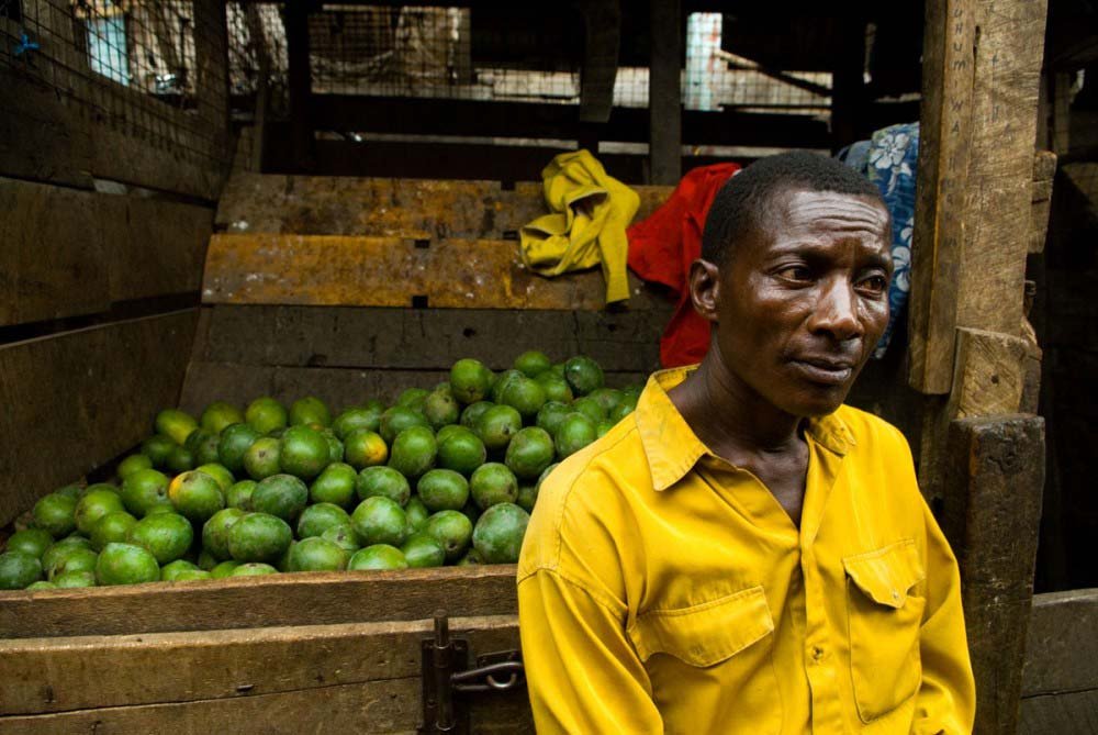 man in yellow shirt selling limes