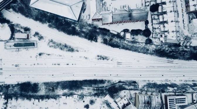 Aerial view of road and buildings coated with snow
