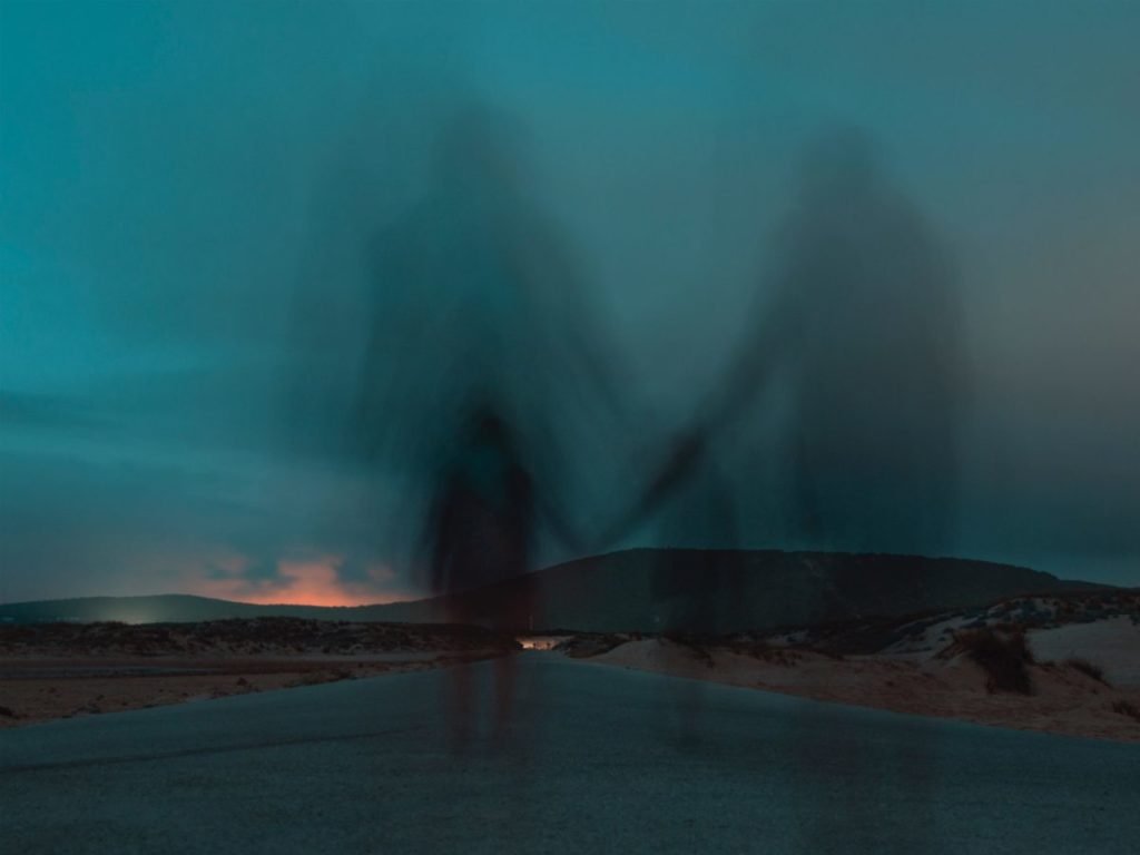 Shadowy figures walking into twilight sky