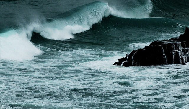 B/W photo of ocean wave against rocks