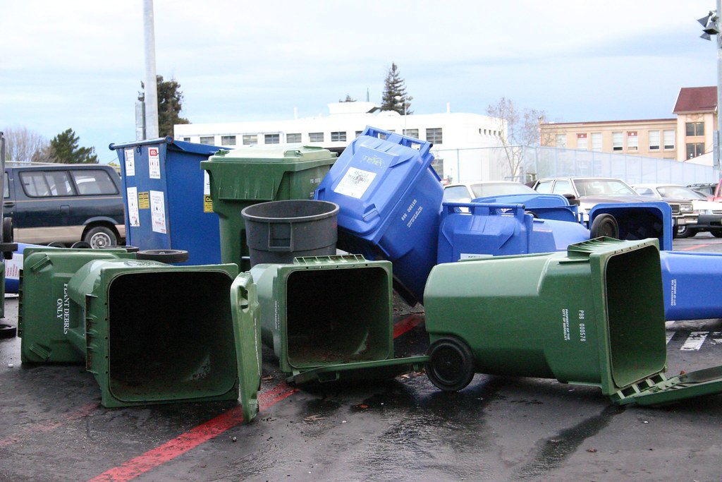 Multiple large garbage cans on their sides
