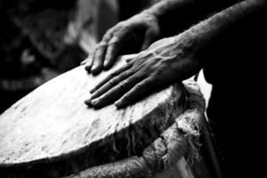 Black and white photo of hands playing a drum