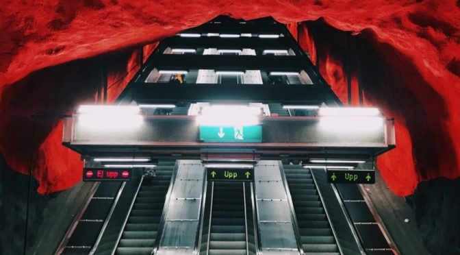 Escalators and building leading to a red tunnel