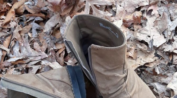 worn brown boots in leaves