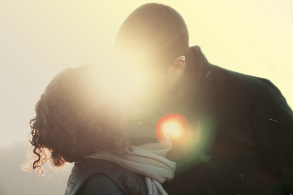 man and woman kissing in sunbeam