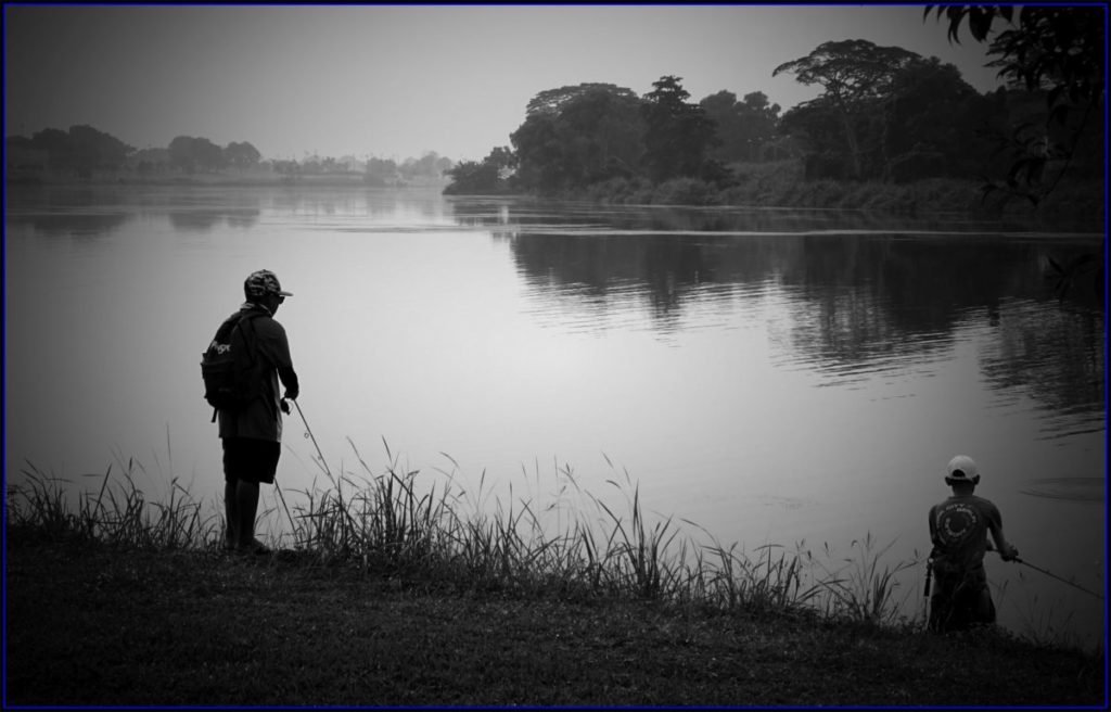 river, man and boy fishing in evening light