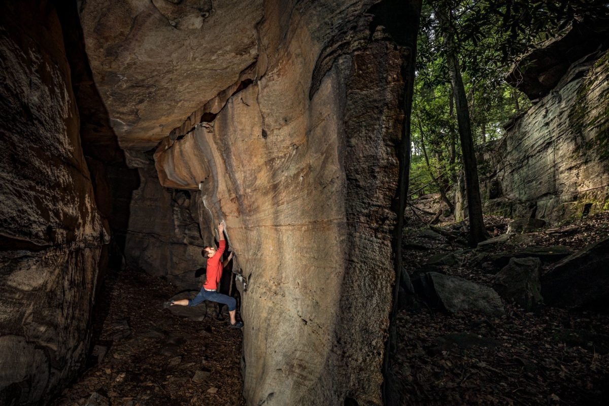 Man climbing alongside cave