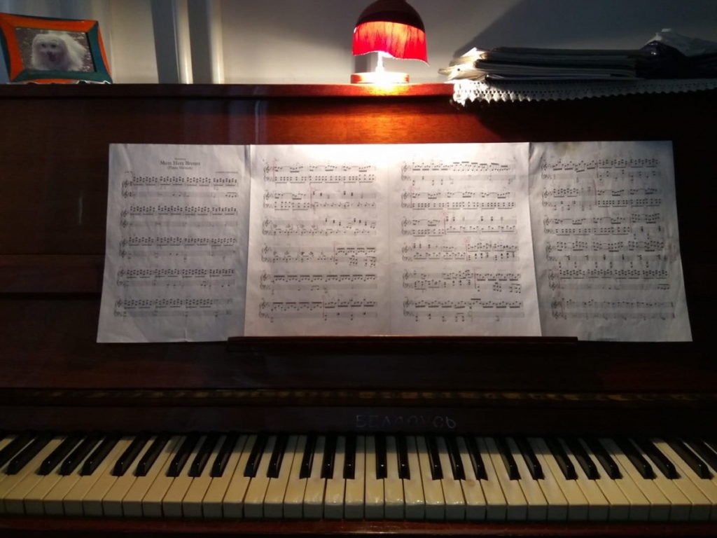 Photo of open piano with music sheets