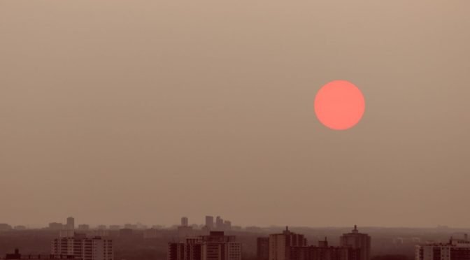 Photo of red sun above skyline