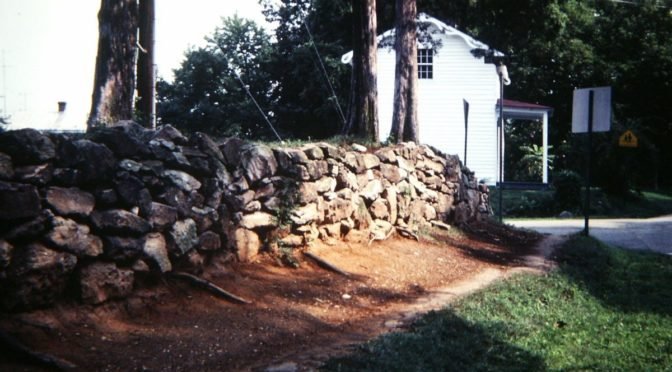 Stone wall leading to white house