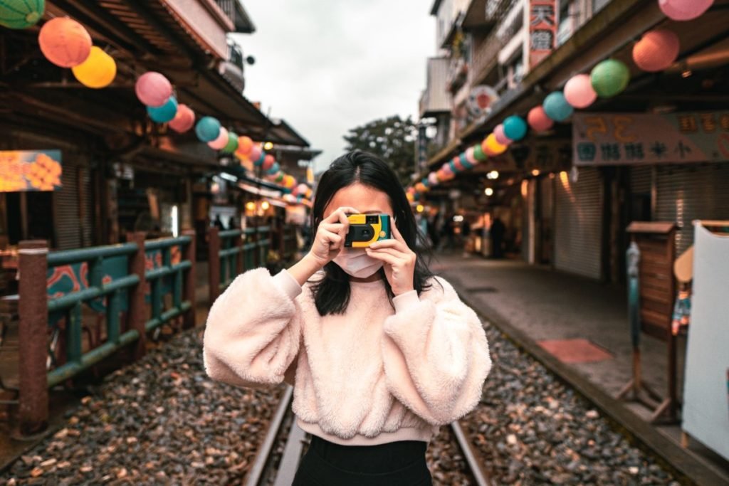 Photo of woman, facing camera, taking a picture