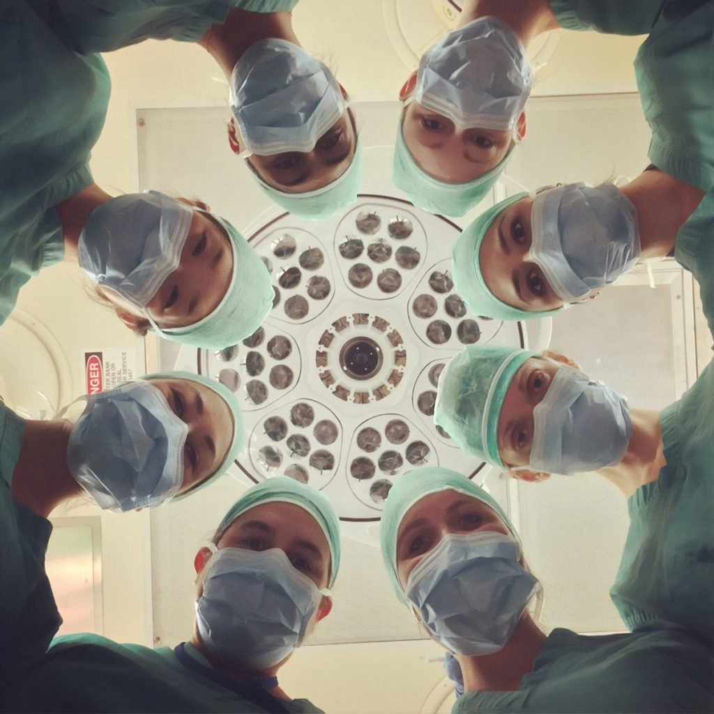 Photo looking up at a circle of doctors' faces