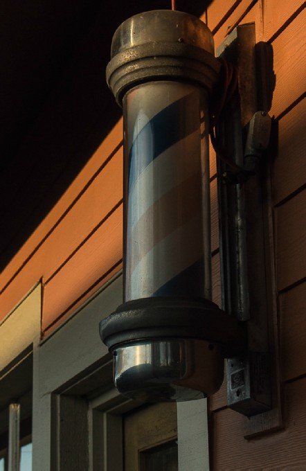 Close up photo of barber pole on building