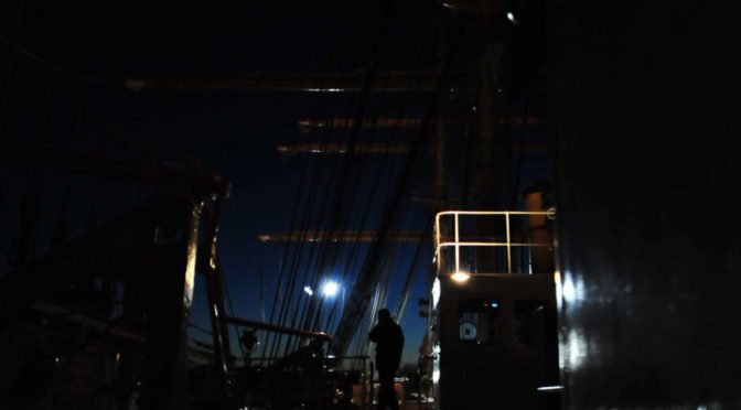 dark figure on a boat at night