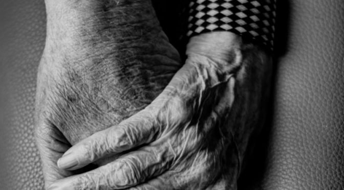 Photo of two old hands holding each other