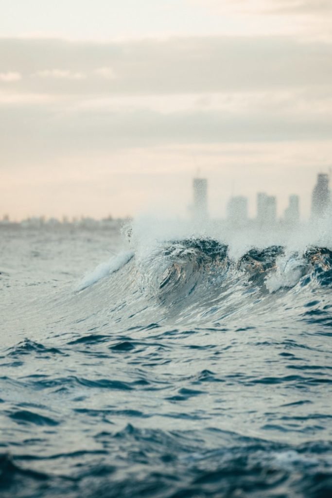 Photo of waves with city in background