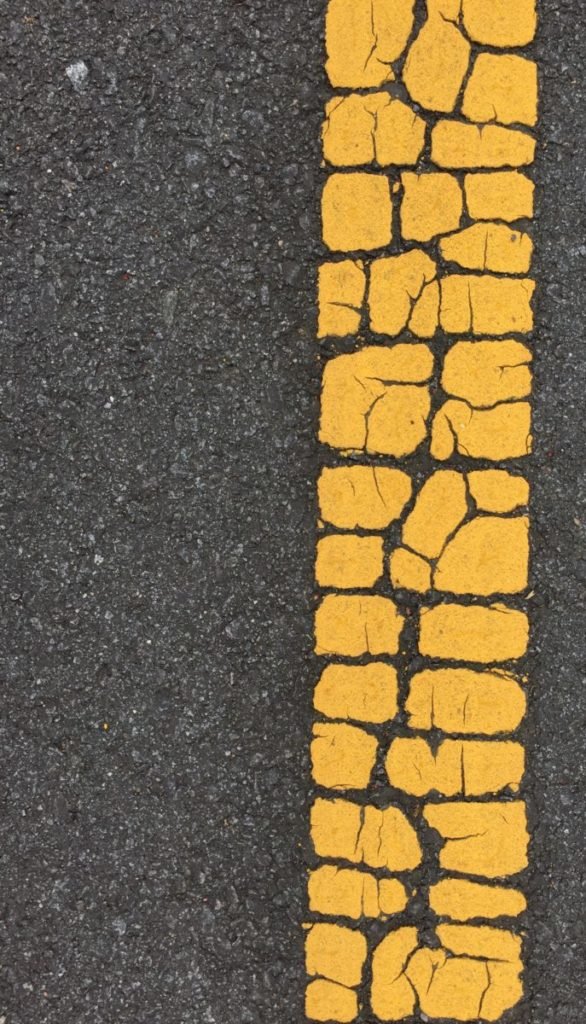 Photo of cracking yellow line in street