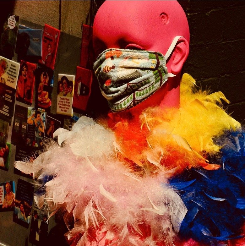 Photo of mannequin with feather boas wearing a mask