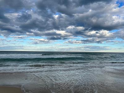 Photo of ocean under sky with clouds