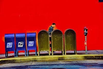 Photo of man walking by many mailboxes