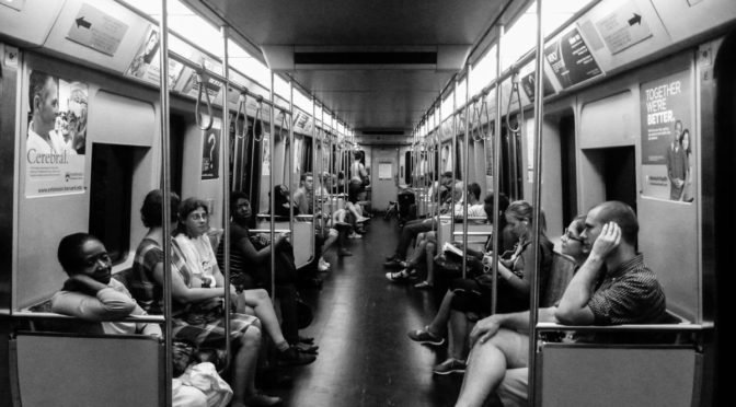 Black and white photo of people in a subway car