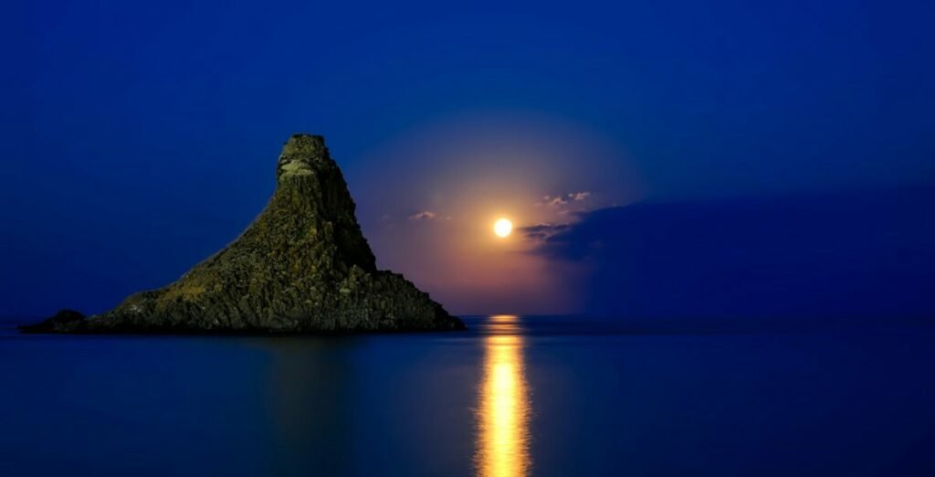 moonlight on night sea with large rock