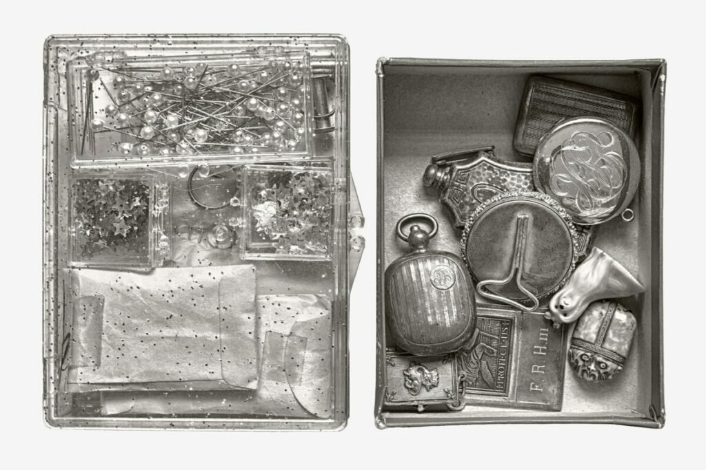 Black and white photo of lockets, hatpins, and clasps