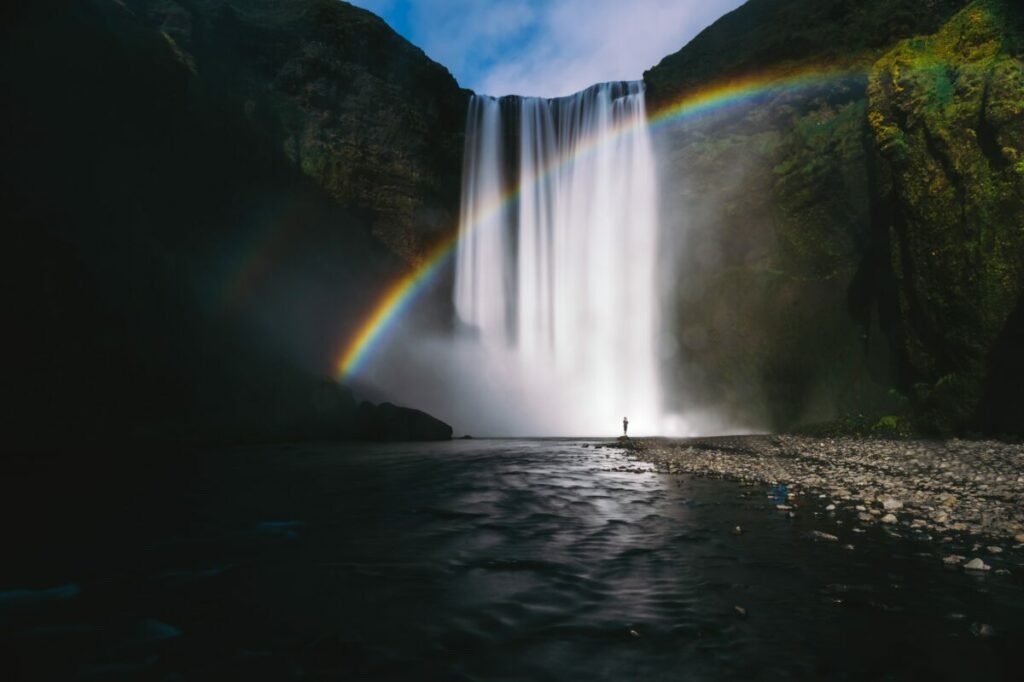Photo of waterfall with rainbow through it