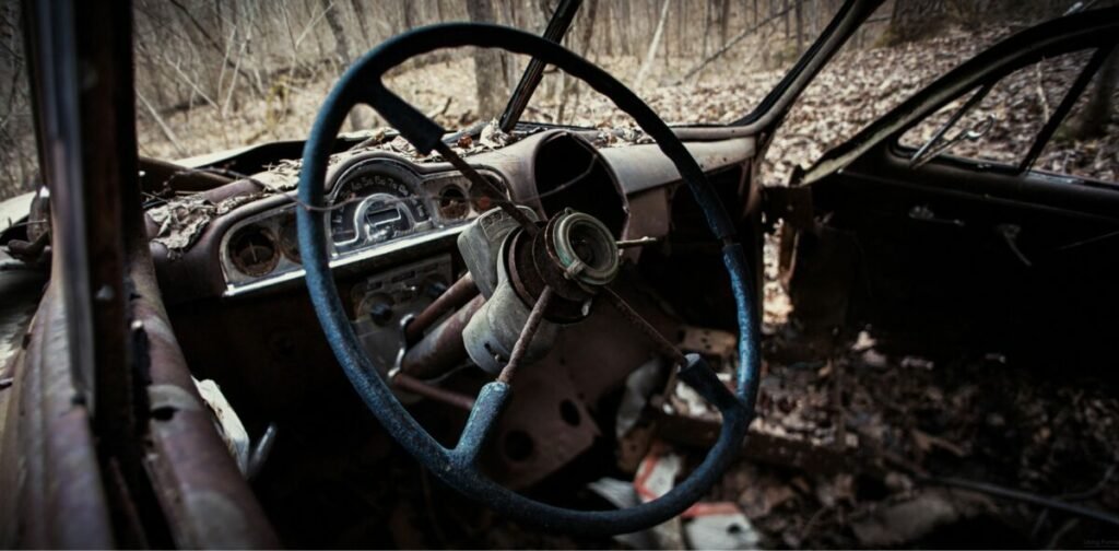 Photo of inside front of a rusty, abandoned car