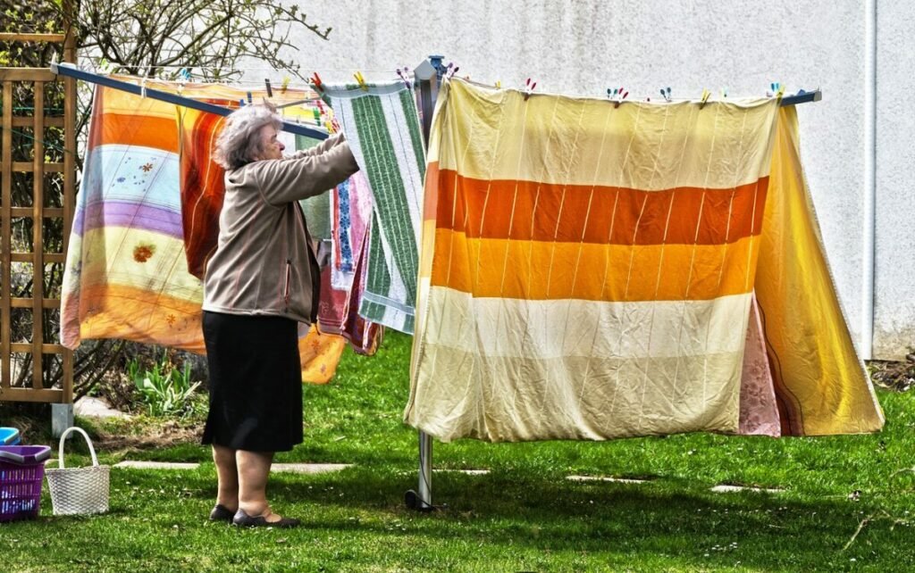 Photo of woman hanging colorful blankets drier