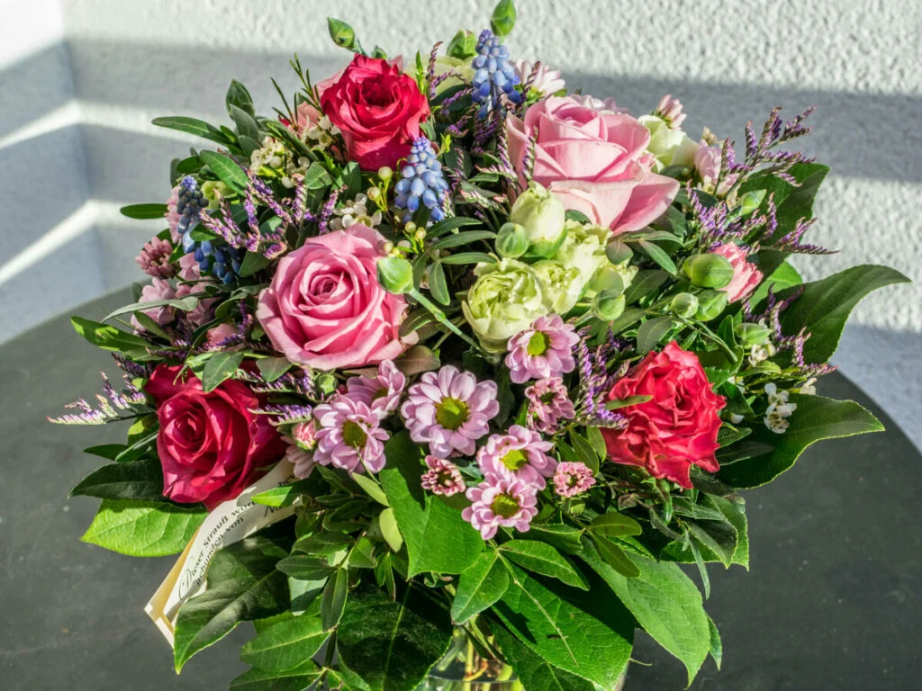 Bouquet of red, purple, and green flowers, amongst green leaves