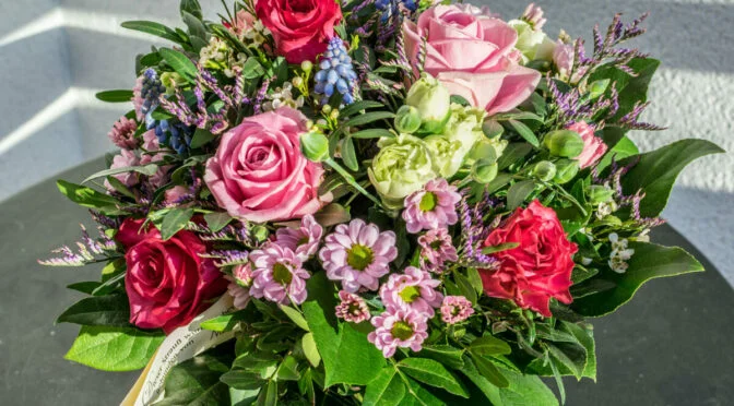Bouquet of red, purple, and green flowers, amongst green leaves