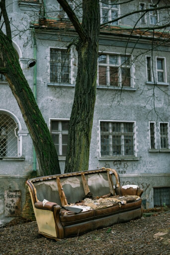 Photo of old building with ruined couch sitting in front