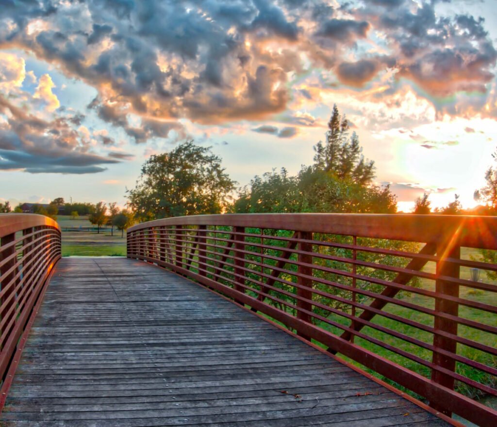 Photo of bridge to field under sunset