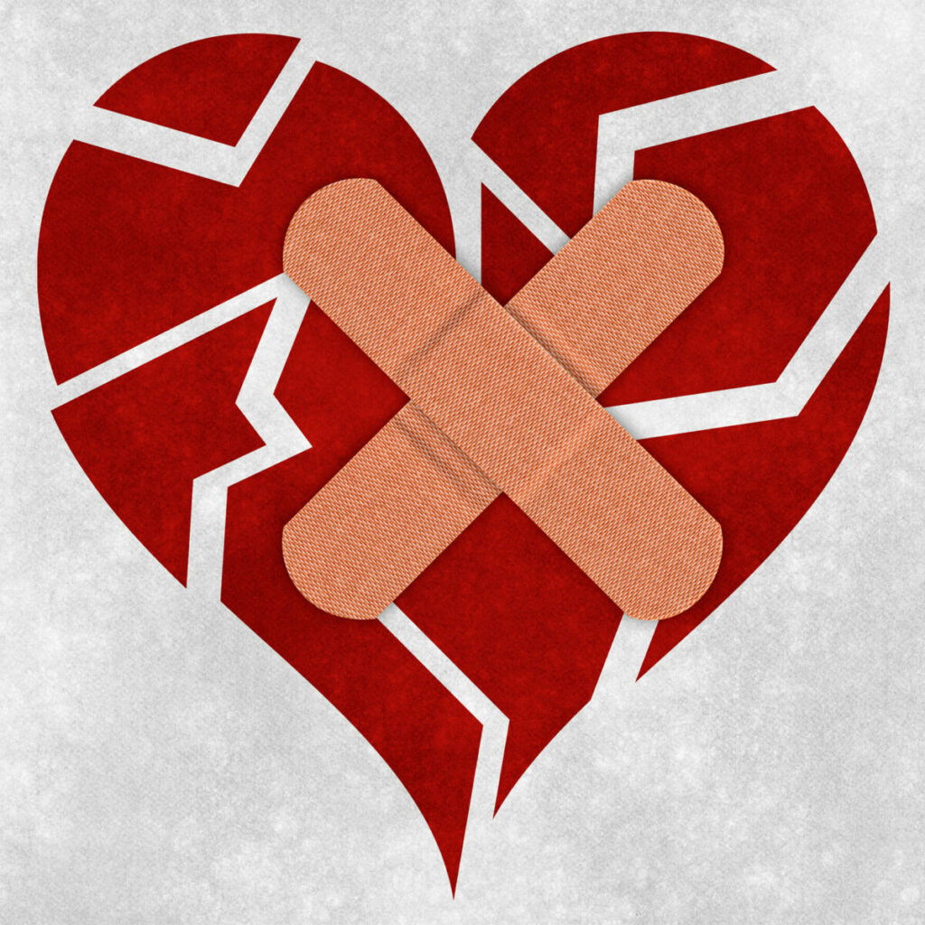 Drawing of a heart, split in many pieces, with two bandaids criss crossed on top
