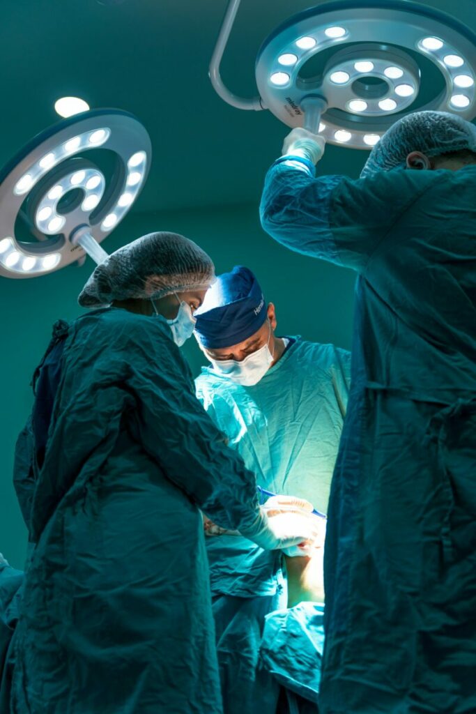 Photo of doctors adjusting lights above patient in surgery