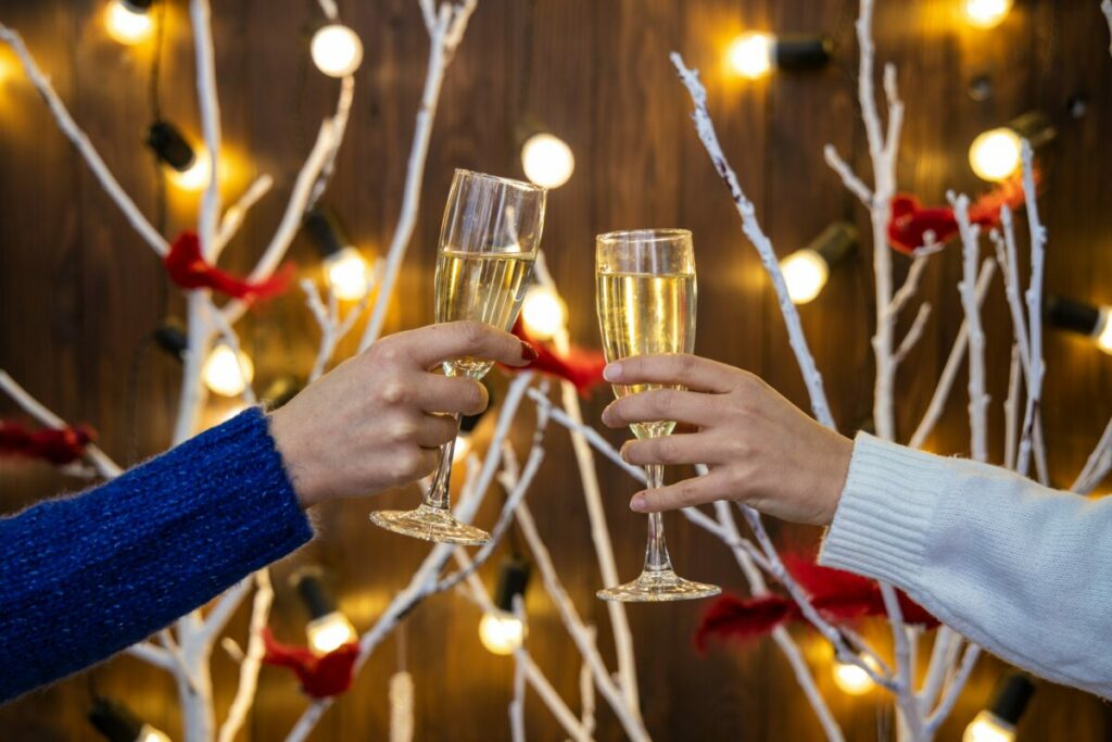 Photo of two hands cheersing with glasses of champagne