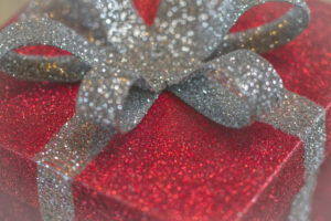 Photo of boxed wrapped in sparkly red paper and sparkly silver bow