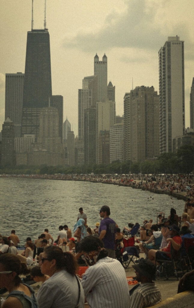 Photo of very crowded beach with skyscraper in background