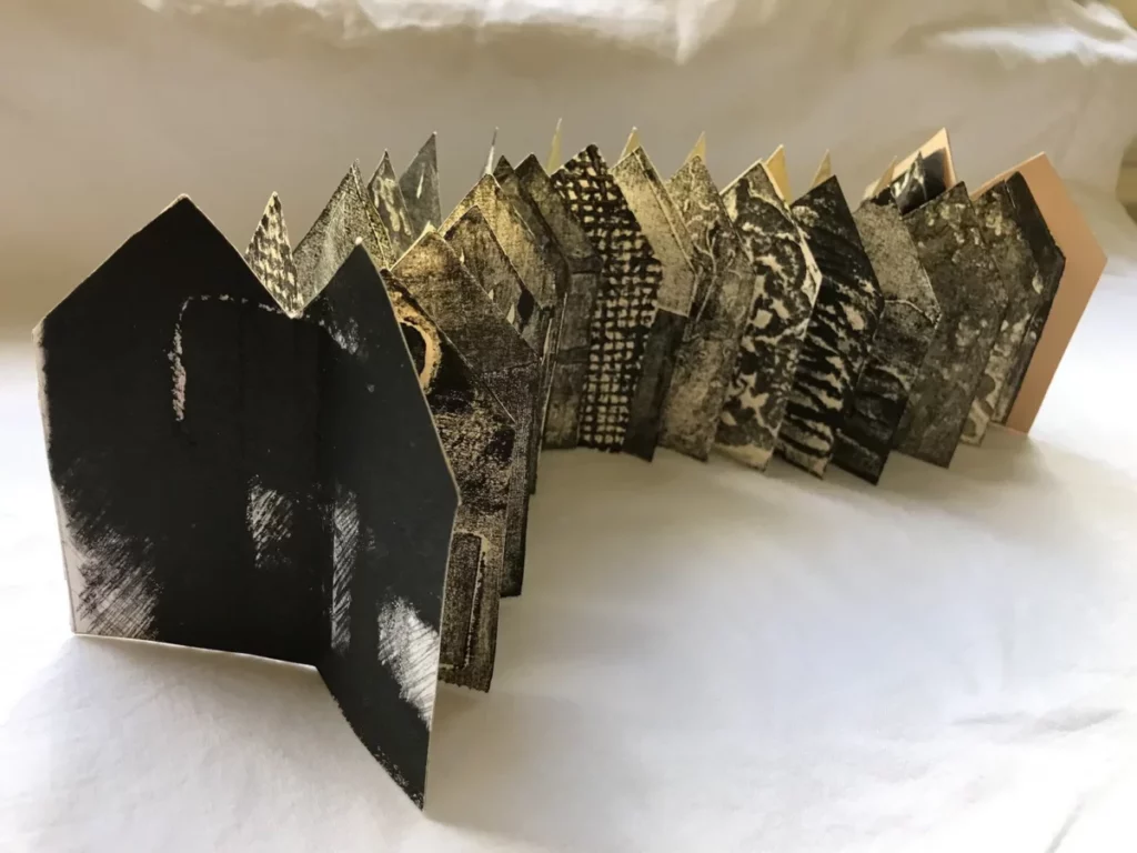 Sculpture made from a book, with each page shaped like a house with double roofs