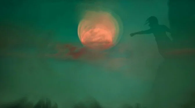 Abstract photo of person in silhouette reaching toward orange sun, all filtered with a green haze