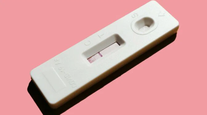 Photo of pregnancy test on pink background