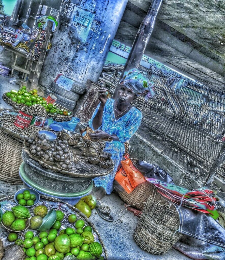 Digitally altered photo of woman sitting amongst wares at the market