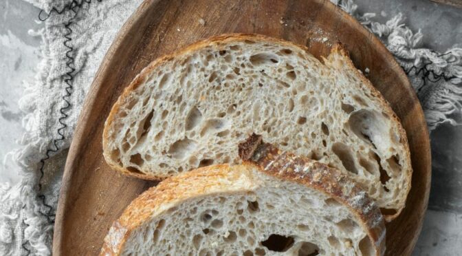 Photo of sliced fresh bread, with jam and rest of loaf on the side