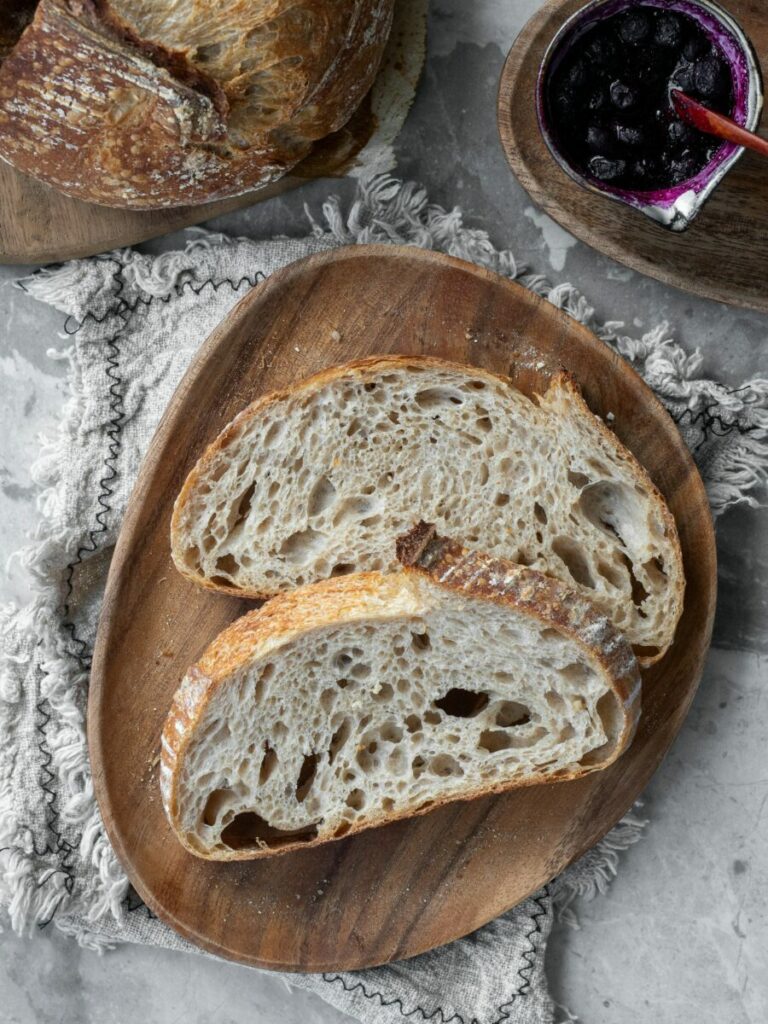 Photo of sliced fresh bread, with jam and rest of loaf on the side