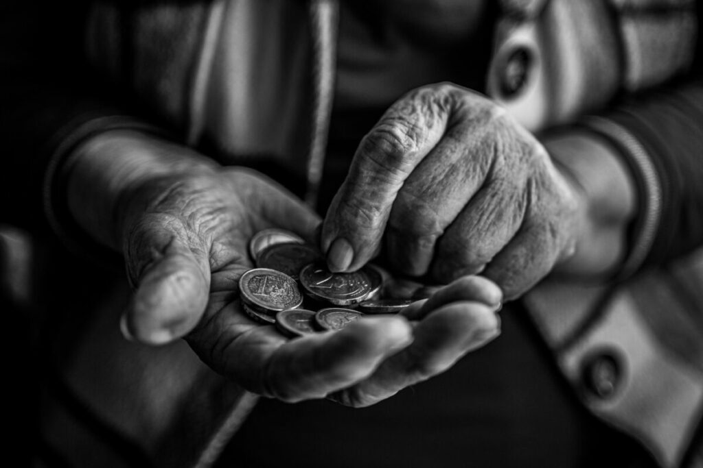 Black and white photo of hands holding coins